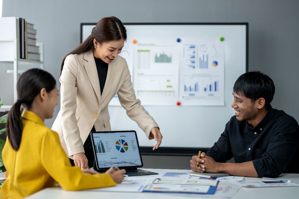 Team discussing business performance reports and financial dashboards during an office meeting