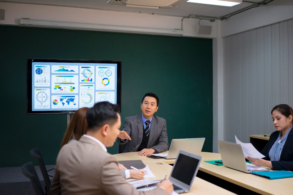 Business meeting with digital analytics displayed on a screen, symbolizing IQ Ecom implementation and sales performance insights.