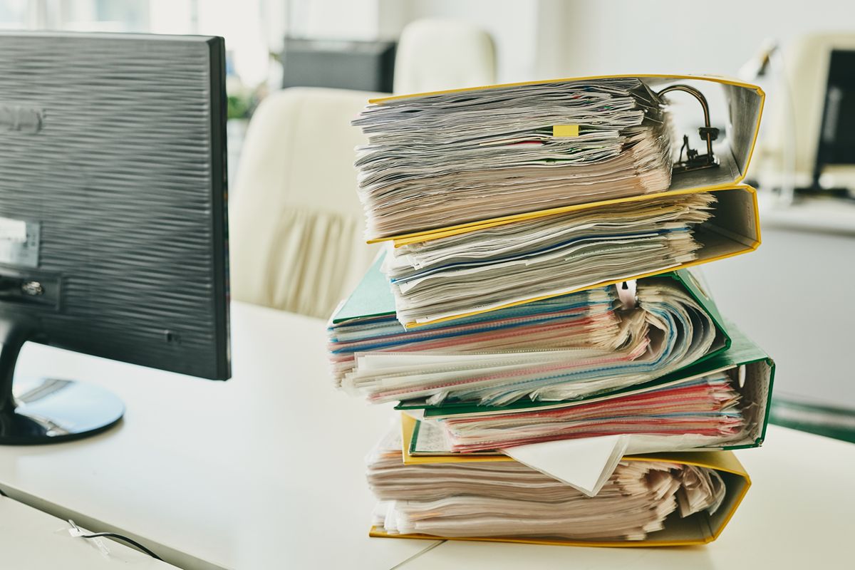 Stack of office folders and documents representing incomplete BIR CAS requirements and compliance delays