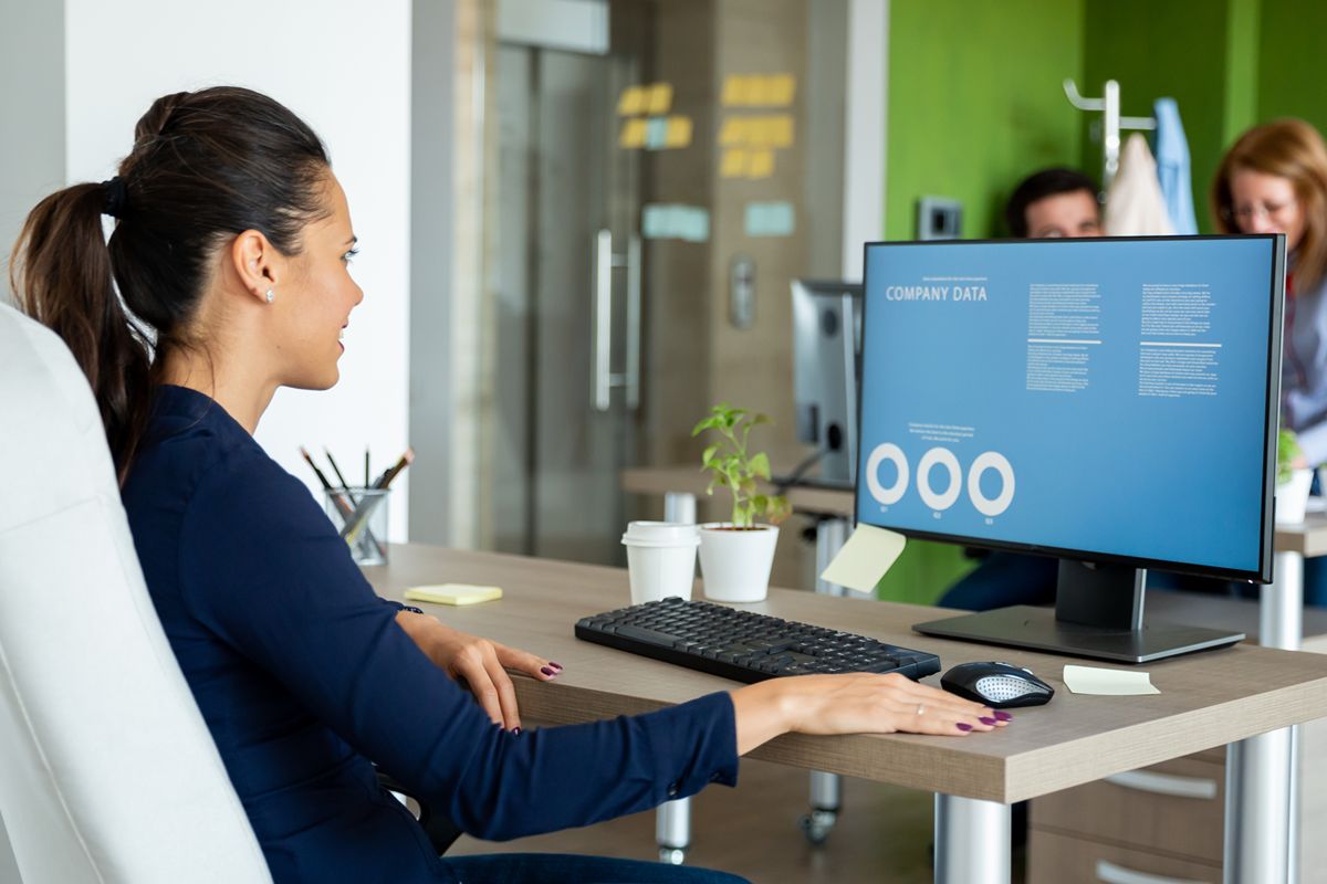 Business professional analyzing inventory and company data on a desktop computer to improve stock control and planning