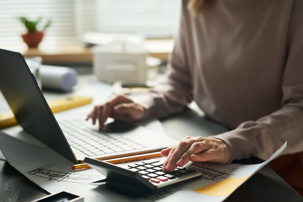 Accounting professional using a laptop and calculator for financial analysis