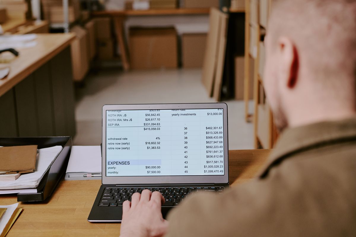 Employee reviewing financial and inventory data on a laptop to support accurate reporting and cost tracking